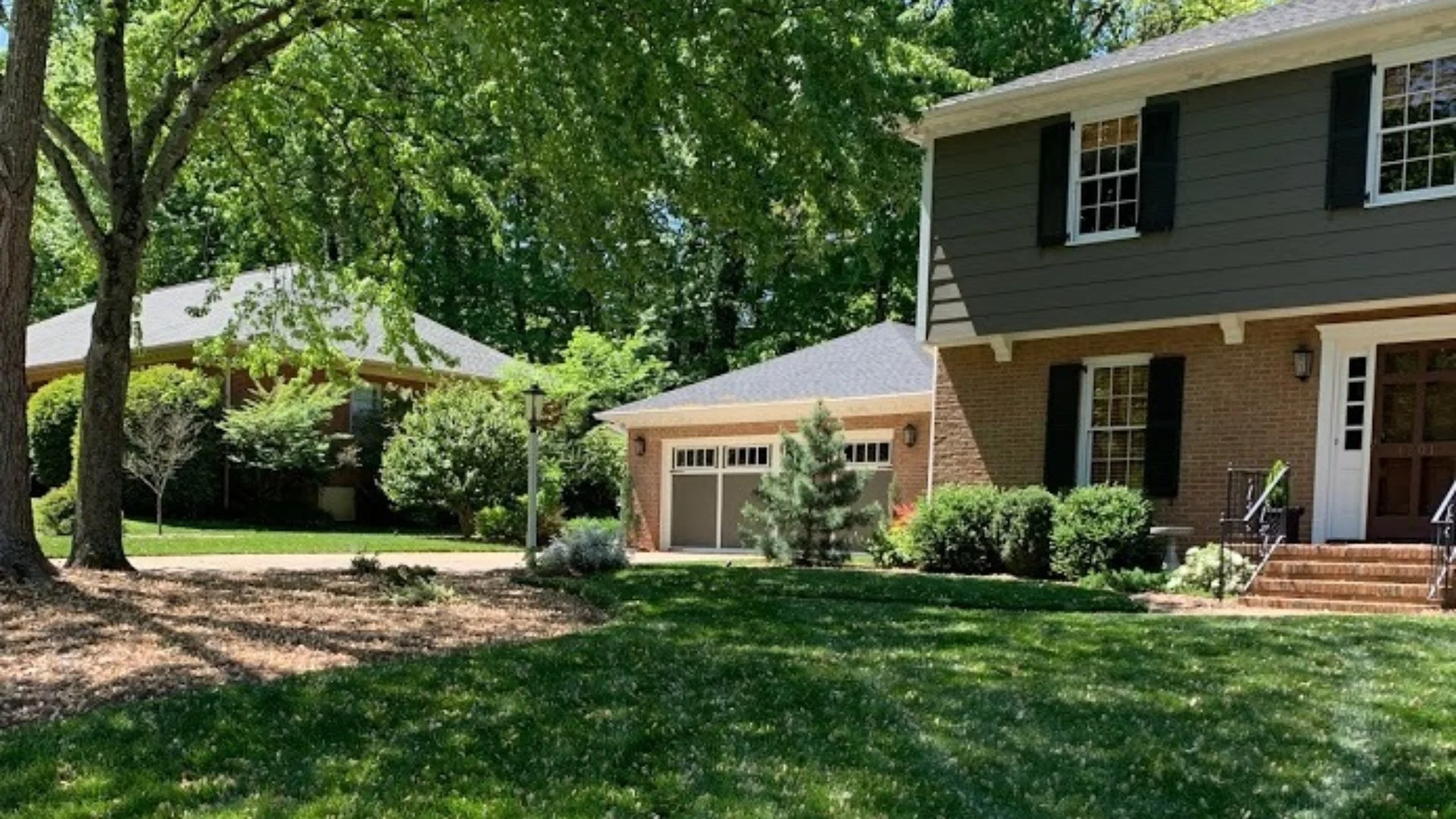 Residential house with a green lawn, healthy trees, and shrubs in Mooresville, NC.