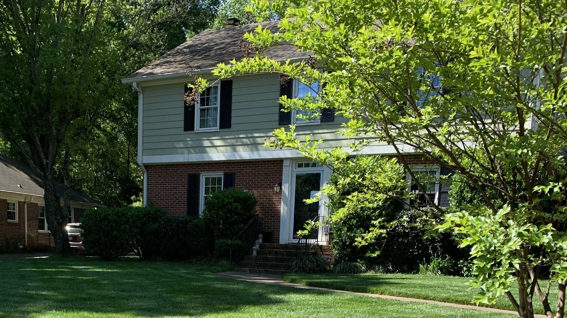 A large tree in front of a well-maintained house with a green lawn and clear skies in Rock Hill, SC.