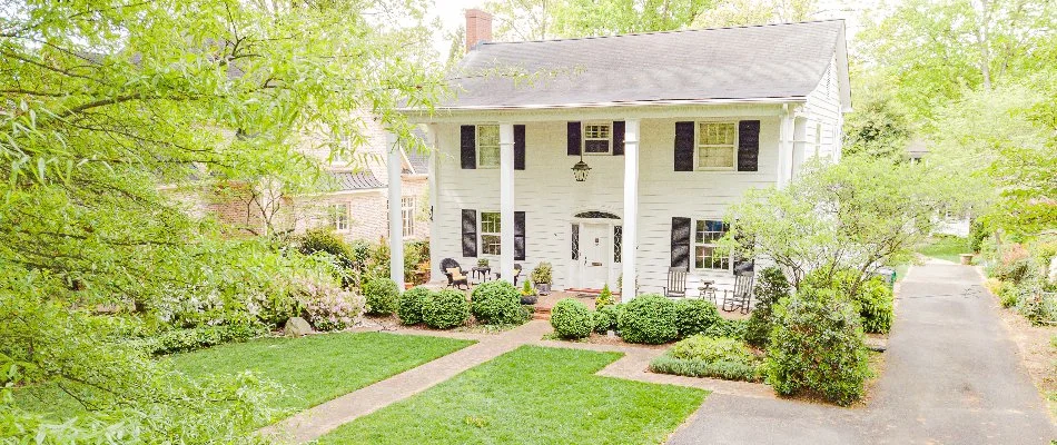 Landscape with small shrubs and trees on a white home in Waxhaw, NC.