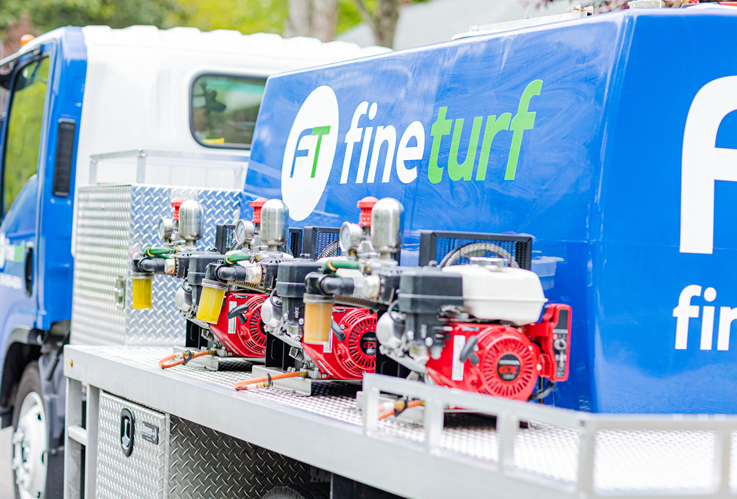 FineTurf service truck with equipment showcasing professional lawn care tools and branding.